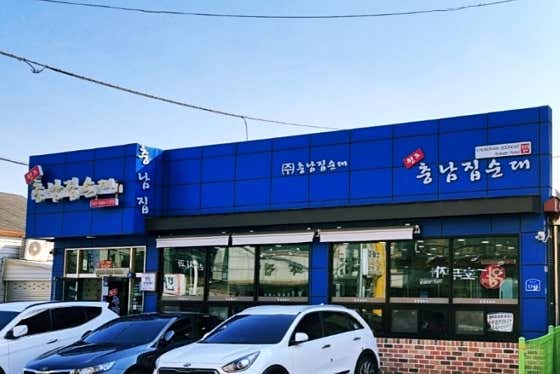파란 간판과 건물 앞 자동차가 보이는 충남집순대 외관