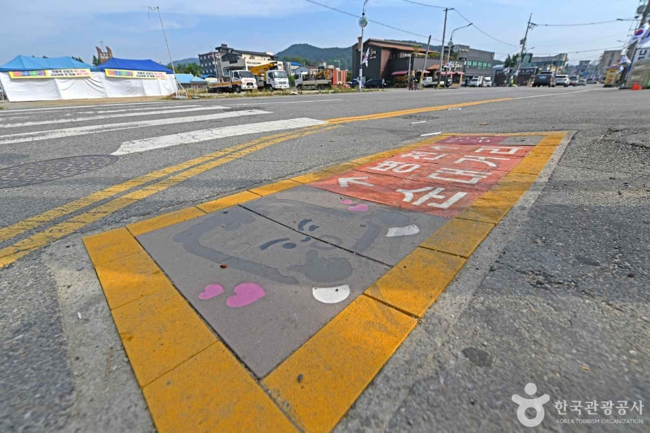 병천순대거리 도로 바닥의 순대 캐릭터 그림과 주변 거리 · 자료사진