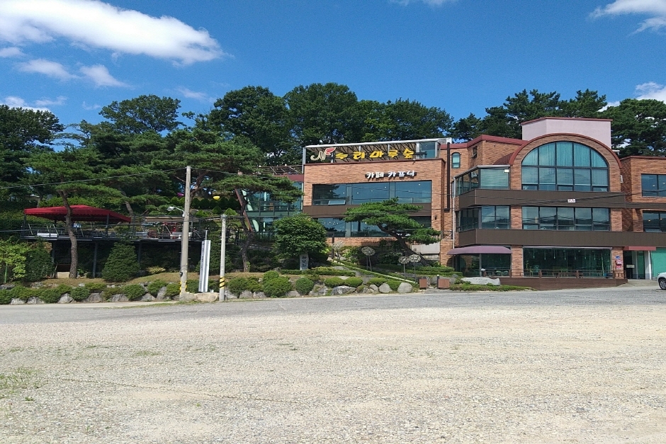 누리마루숲 건물 앞 넓은 비포장 공간과 건물 전경 · 자료사진