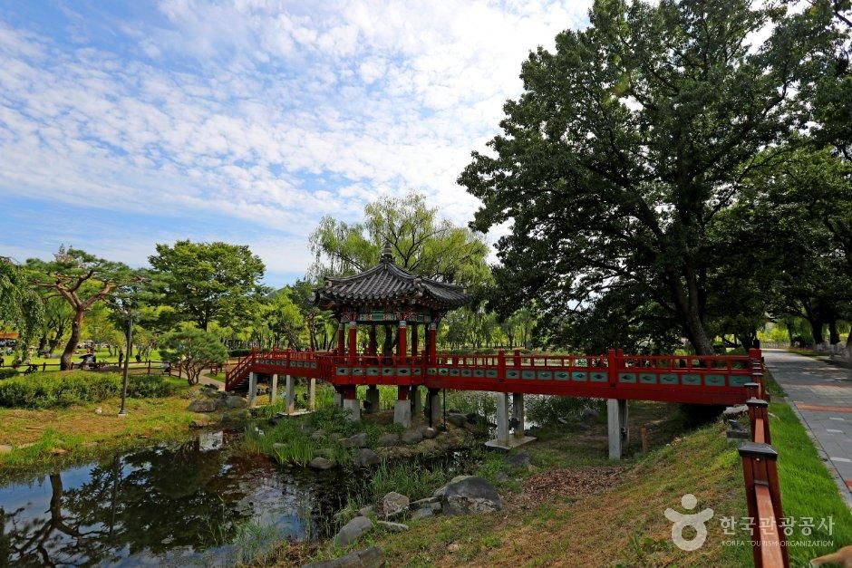 연못과 붉은 다리, 나무 뒤편으로 보이는 정자 · 자료사진