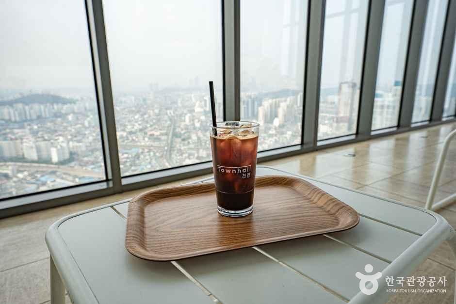 창가 테이블에 놓인 커피 한 잔과 창밖 천안 도심 · 자료사진