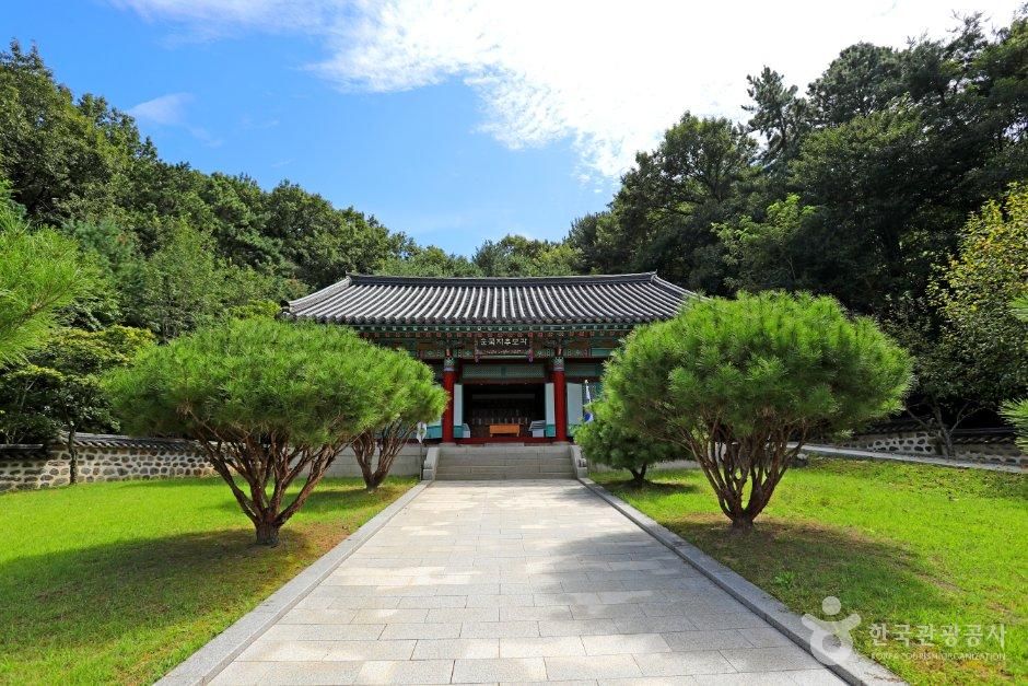 나무와 진입로 너머 순국자추모각 현판이 보이는 건물 · 자료사진