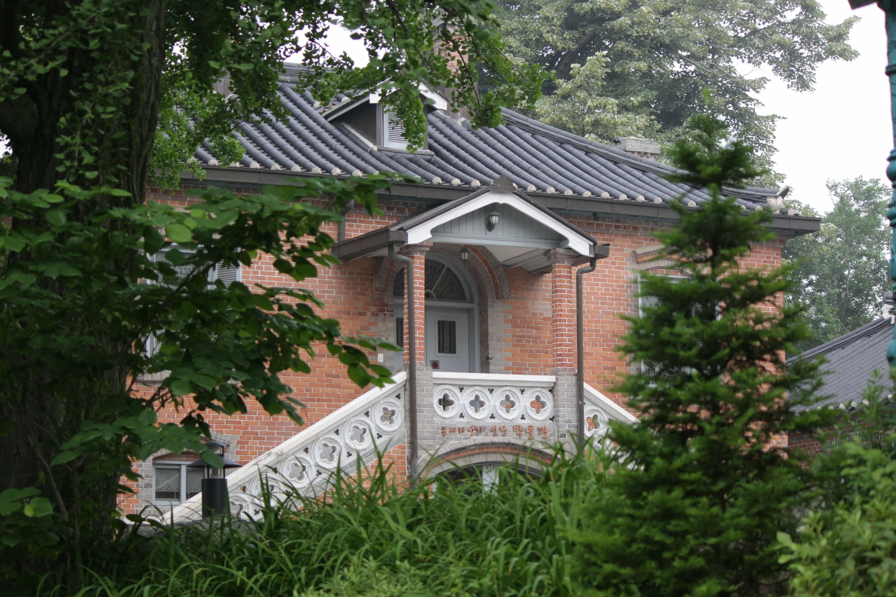 초록 나무에 둘러싸인 붉은 벽돌 박물관 외관, 2013년 6월