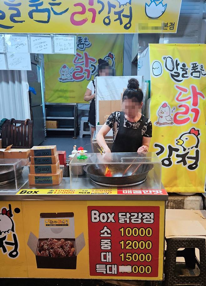 알을품은닭강정 간판 앞에서 조리 중인 점포 모습