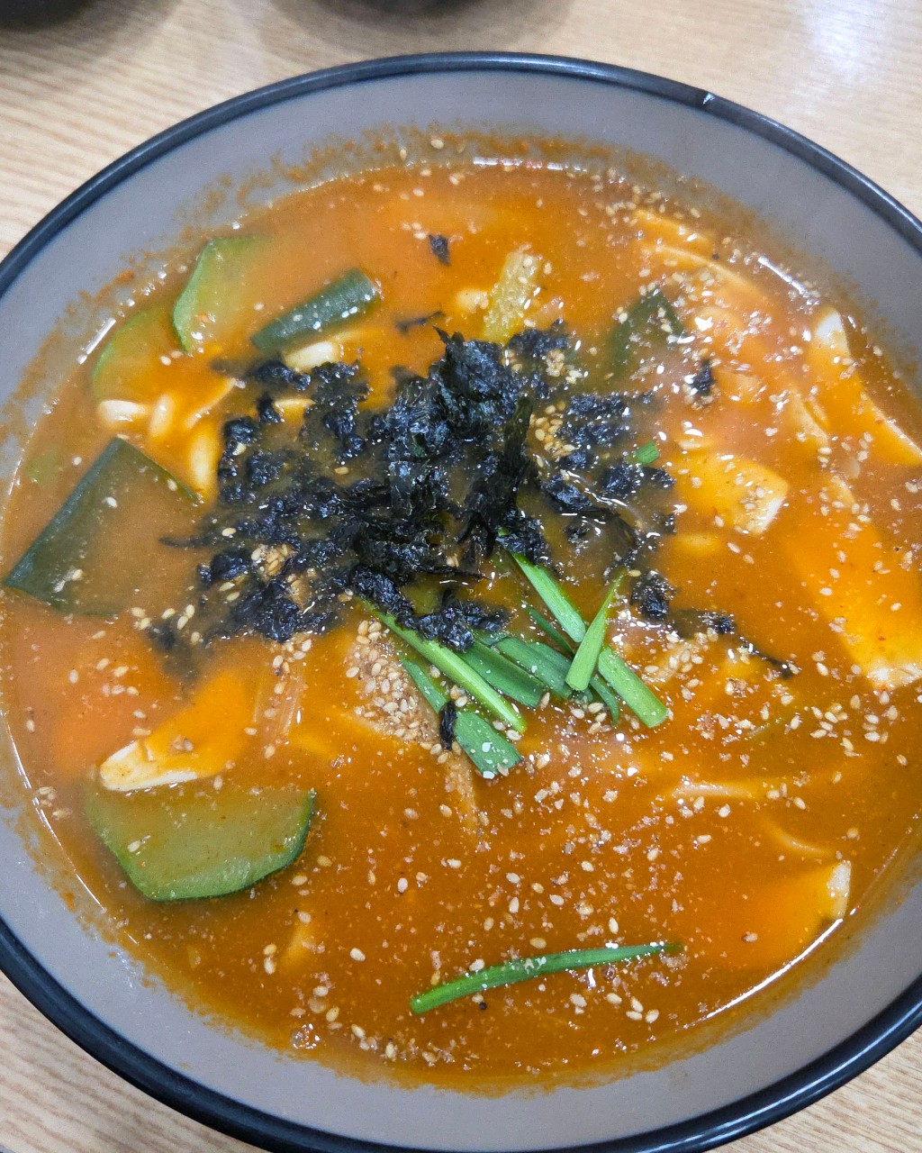 김과 채소가 올라간 붉은 국물의 장칼국수